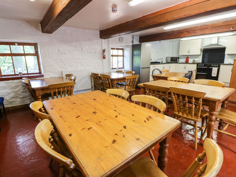 A dining room with wooden tables and chairs at West Barn