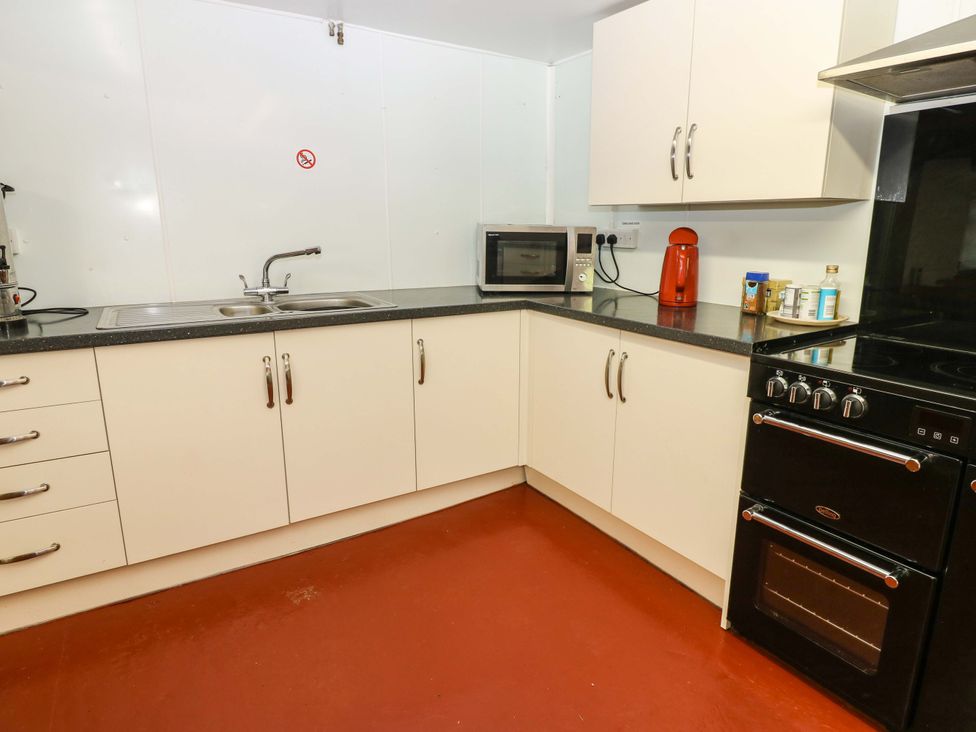 A kitchen with sink, microwave, kettle, and oven at West Barn 