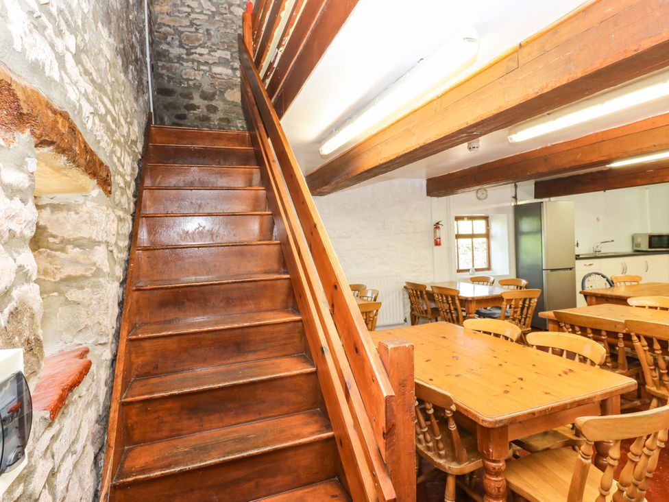 A staircase leading to the upper level next to dining tables at West Barn
