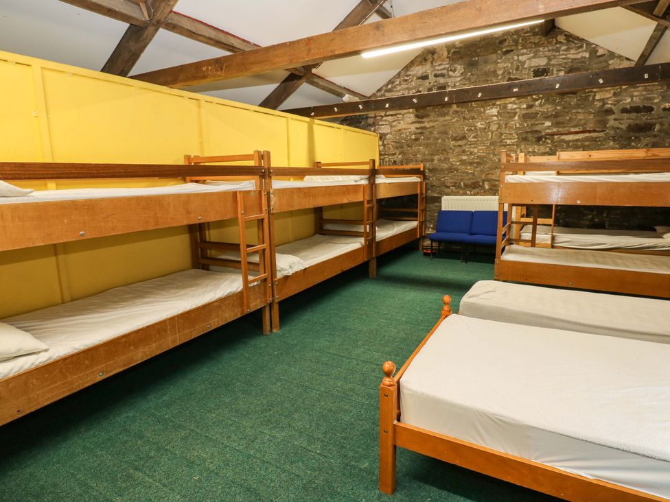 A sleeping area with bunk beds and a couch at West Barn 