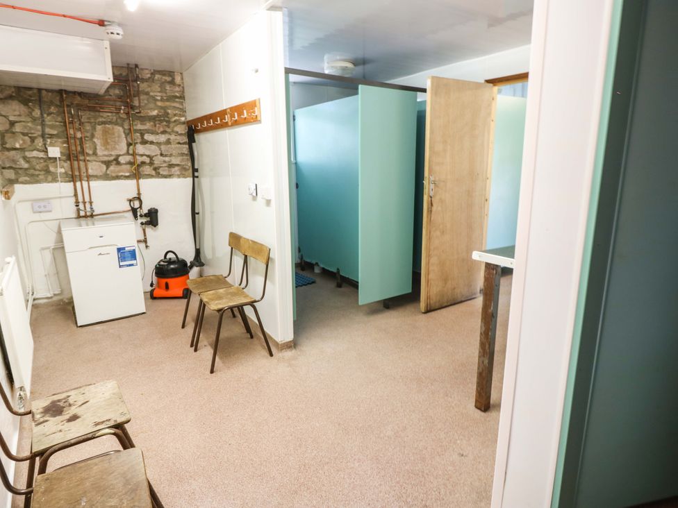 A utility room with washing machine and vacuum cleaner at West Barn