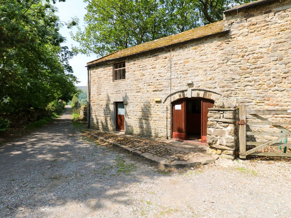 An exterior view of a stone building with a gravel path at West Barn