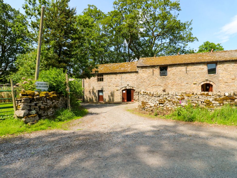 An outdoor area with a stone building and gravel path at West Barn