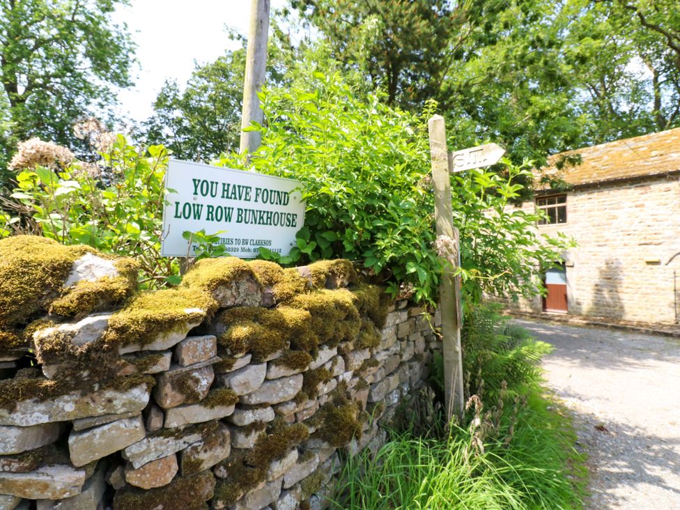 A sign and stone wall at Low Row Bunkhouse
