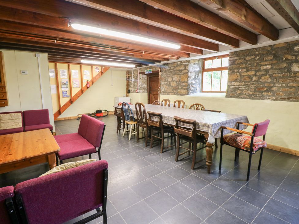 A dining room with a long table and chairs at East Barn Bunkhouse