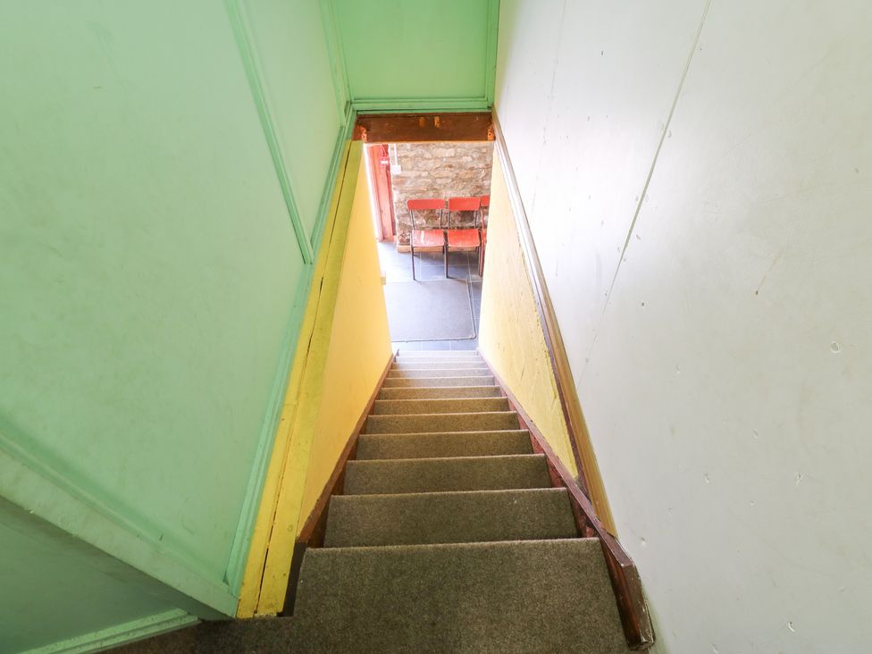 A staircase leading to a room with a table and chairs at East Barn Bunkhouse