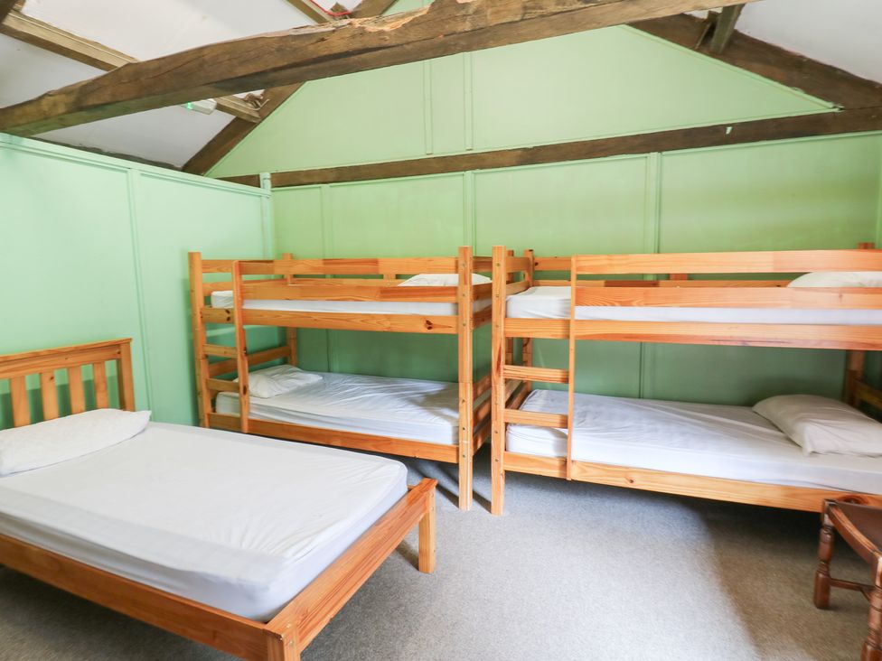 A room with bunk beds and a single bed at East Barn Bunkhouse