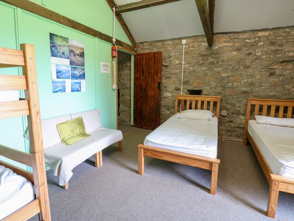 A bedroom with beds and sofa at East Barn Bunkhouse 