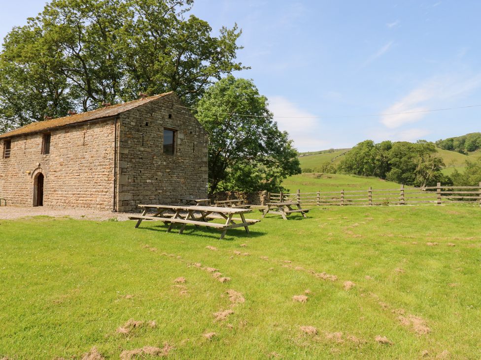 A garden with picnic tables and a building at East Barn Bunkhouse 
