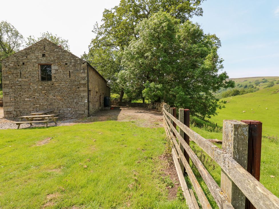 An outdoor area with a stone building and picnic table at East Barn Bunkhouse