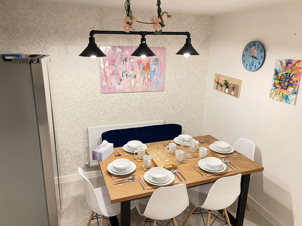 A dining room with a table set for meals at Derby Den in Breadsall near Derby