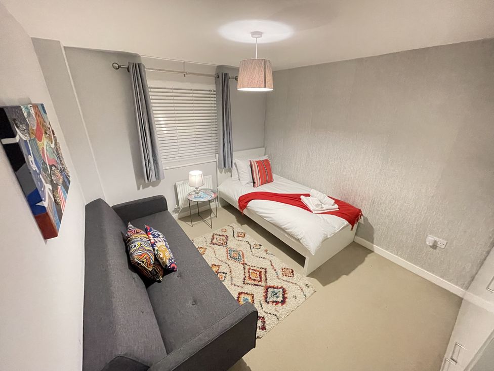 A bedroom with a bed and sofa at Derby Den Breadsall near Derby