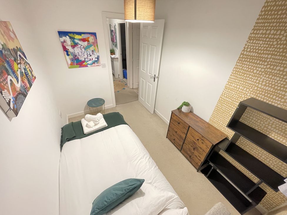 A bedroom with a bed and a shelf at Derby Den in Breadsall near Derby