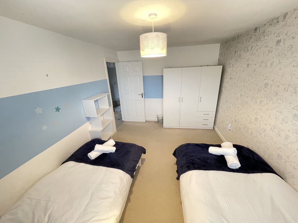 A bedroom with twin beds and storage at Derby Den in Breadsall near Derby