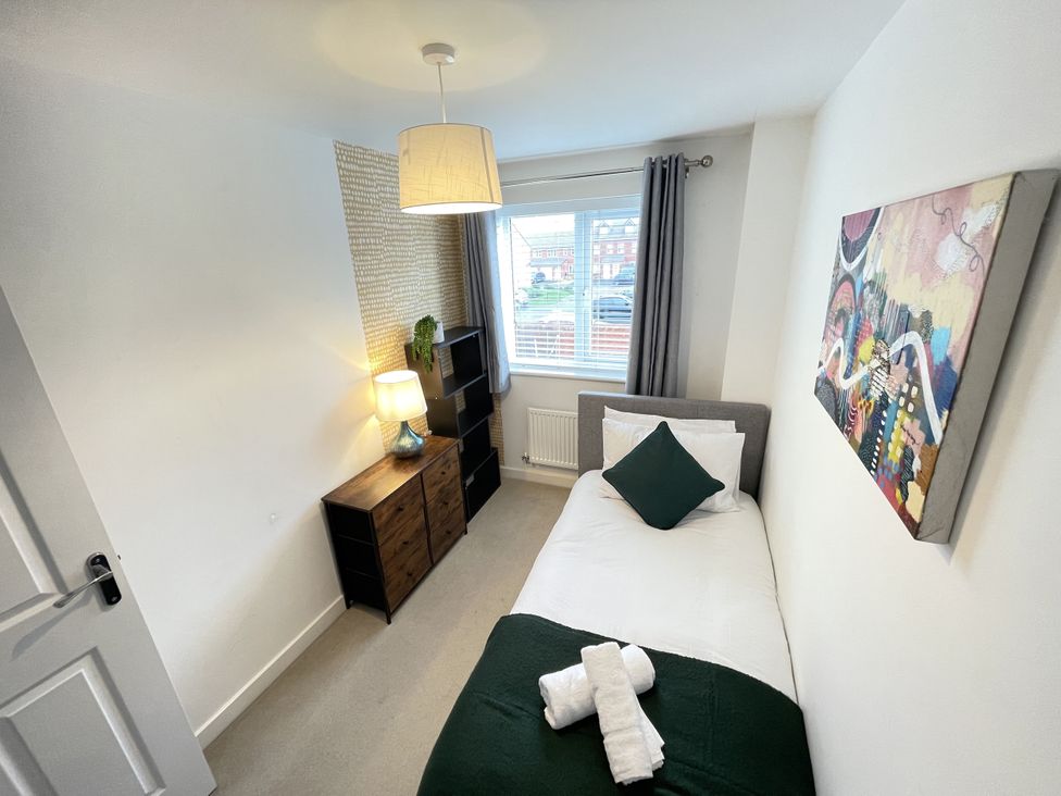 A bedroom with a bed and a lamp at Derby Den in Breadsall near Derby