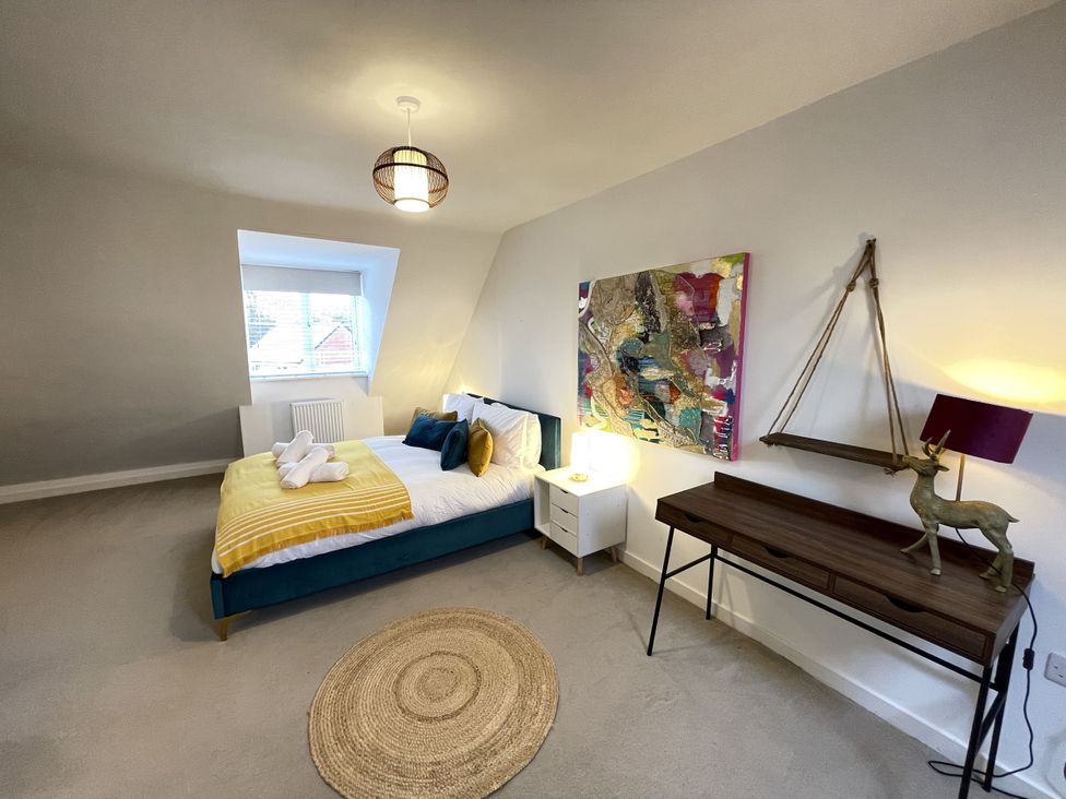 A bedroom with a bed and bedside table at Derby Den in Breadsall near Derby