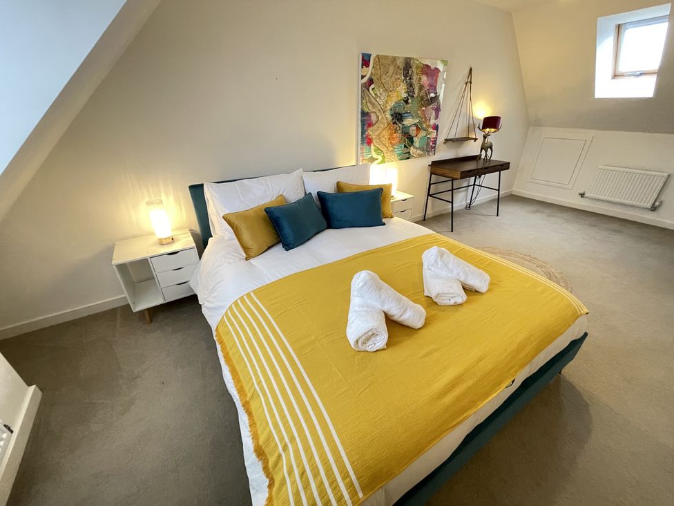 A bedroom with a bed and side table at Derby Den in Breadsall near Derby