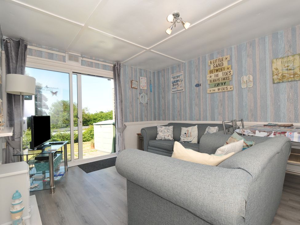 A living room with a sofa and television at 13 Hillside, Bude