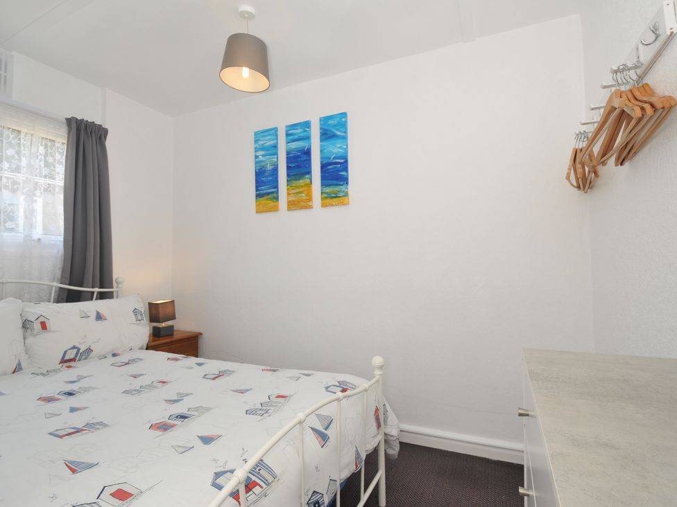 A bedroom with a bed and paintings on the wall at 13 Hillside in Bude