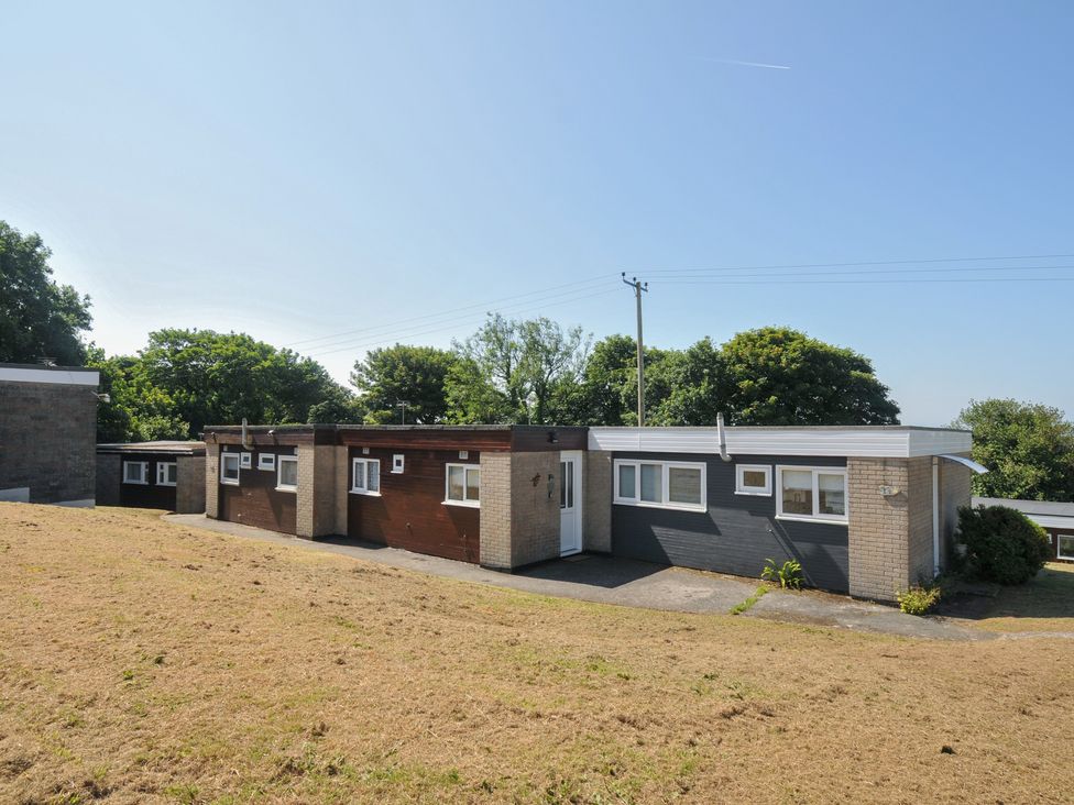 A house with multiple sections and grassy area at 13 Hillside in Bude