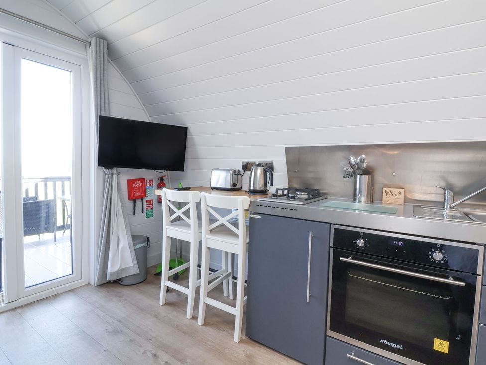 A kitchen with a stove and television at New Pod in Kilkhampton
