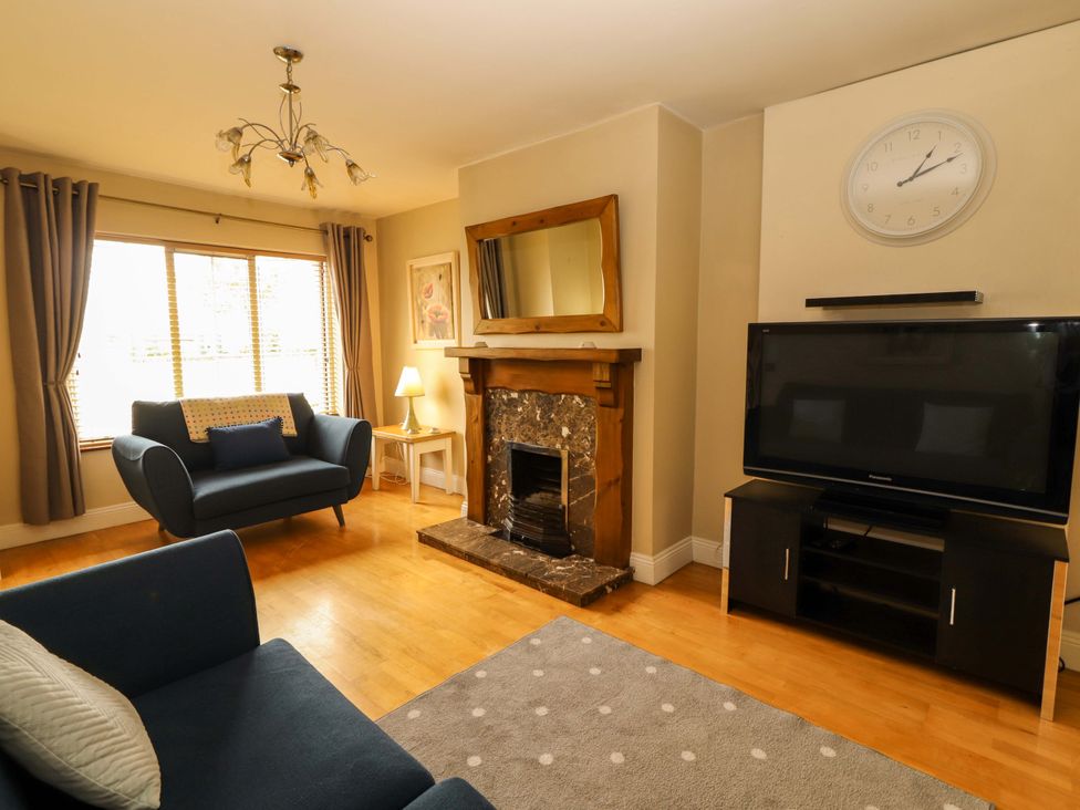 A living room with a sofa, fireplace, and television at 51 Woodview Park in Tralee, County Kerry