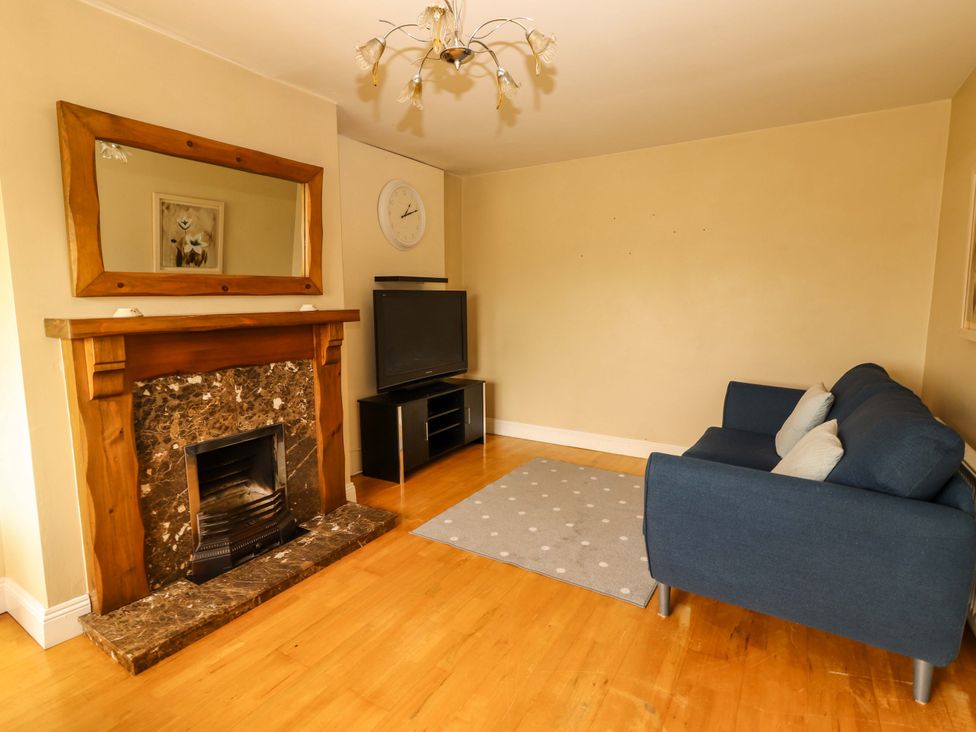 A living room with a fireplace and television at 51 Woodview Park in Tralee, County Kerry