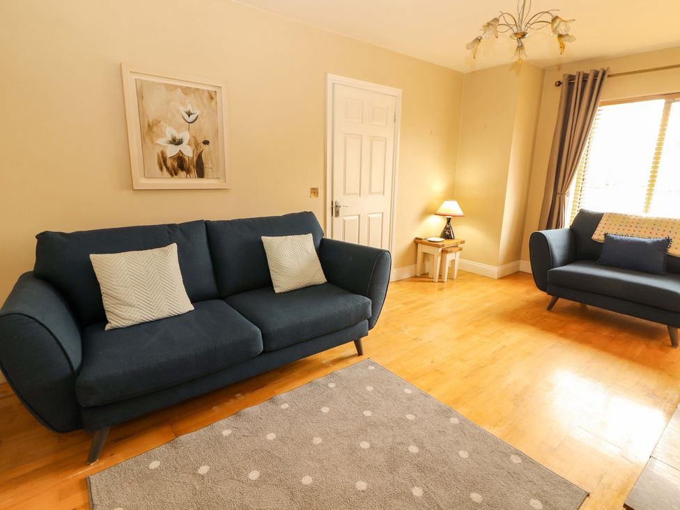 A living room with a sofa and armchair at 51 Woodview Park in Tralee, County Kerry