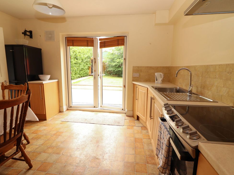 A kitchen with cabinets, sink, and a refrigerator at 51 Woodview Park in Tralee, County Kerry