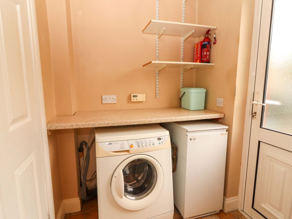 A laundry room with a washing machine and freezer at 51 Woodview Park in Tralee, County Kerry