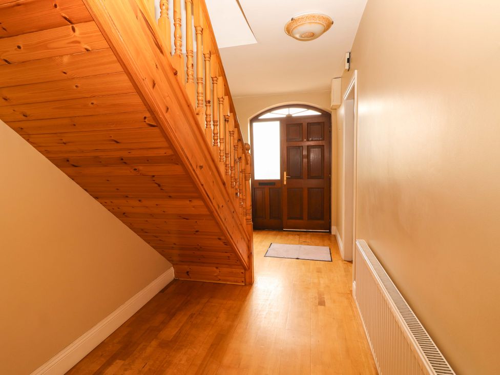 A hallway with stairs and a front door at 51 Woodview Park in Tralee, County Kerry
