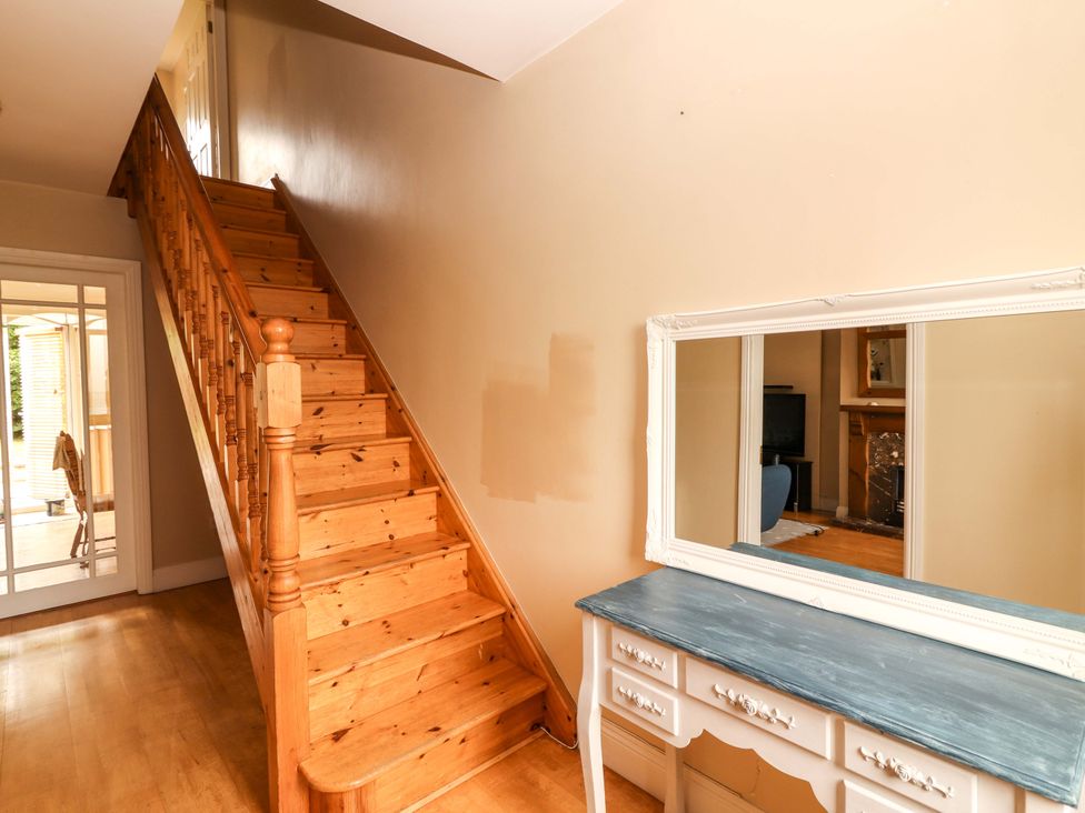 A hallway with a staircase and a console table at 51 Woodview Park in Tralee, County Kerry