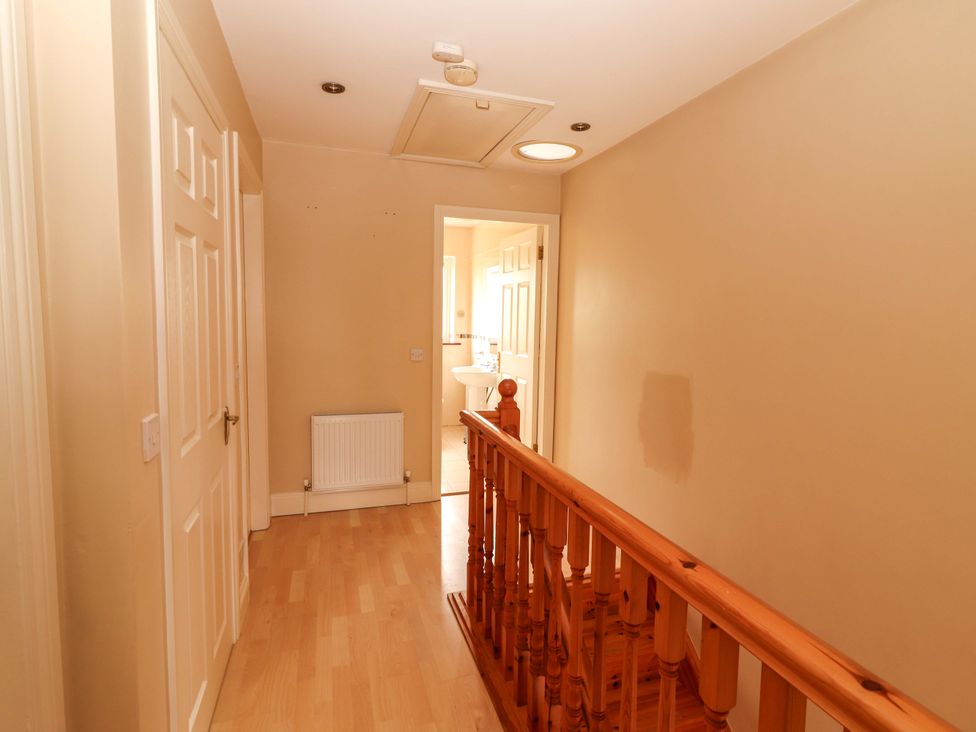 A hallway with a staircase and doors at 51 Woodview Park in Tralee, County Kerry