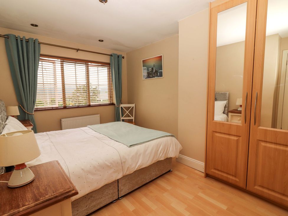 A bedroom with a bed and a wardrobe at 51 Woodview Park in Tralee, County Kerry