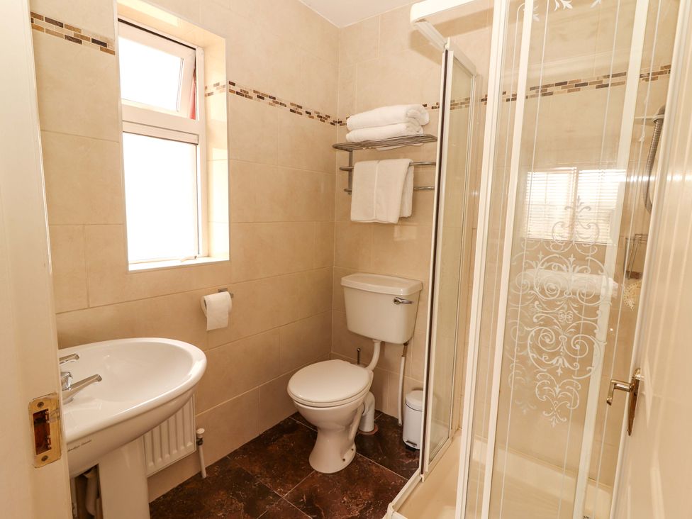 A bathroom with a shower, toilet, and sink at 51 Woodview Park in Tralee, County Kerry