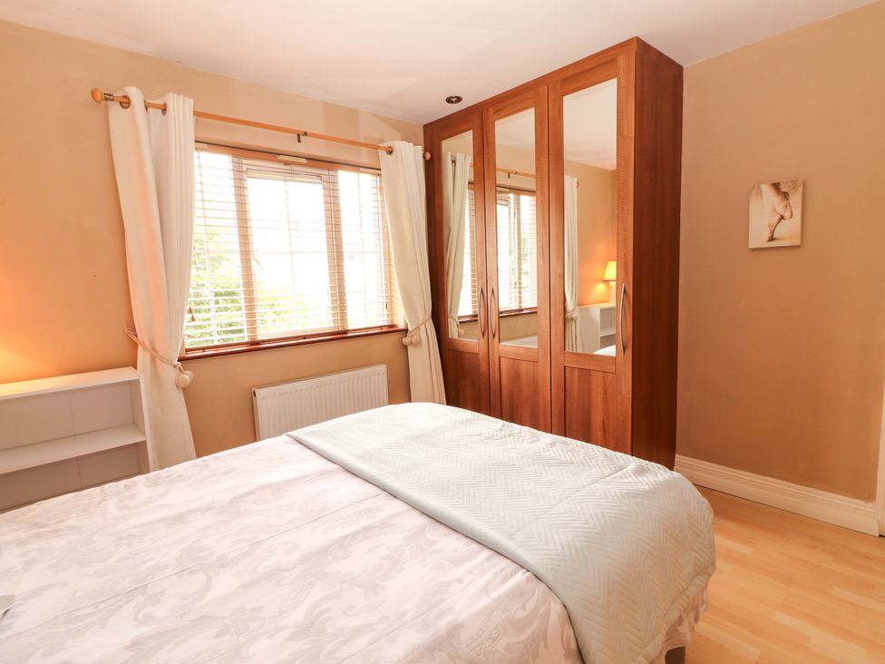 A bedroom with a bed and wardrobe at 51 Woodview Park in Tralee, County Kerry