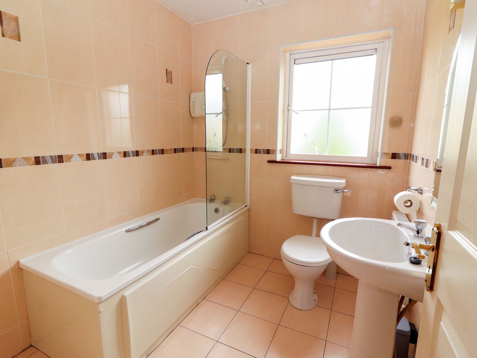 A bathroom with bathtub, toilet, and washbasin at 51 Woodview Park in Tralee, County Kerry