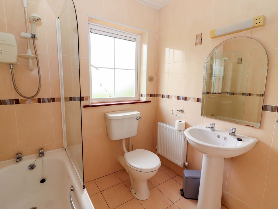 A bathroom with a shower, bathtub, toilet, and sink at 51 Woodview Park, Tralee, County Kerry