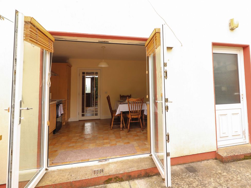A kitchen with a dining area visible through open double doors at 51 Woodview Park in Tralee, County Kerry