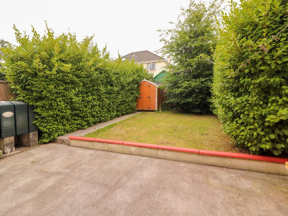 A garden with a shed and hedges at 51 Woodview Park in Tralee, County Kerry