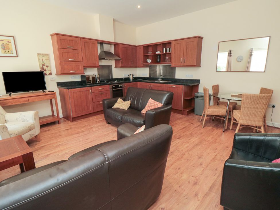 A living room with kitchen area and dining table at 4 Londesborough Mews