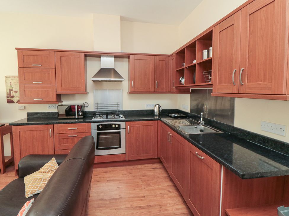 A kitchen with wooden cabinets and appliances at 4 Londesborough Mews
