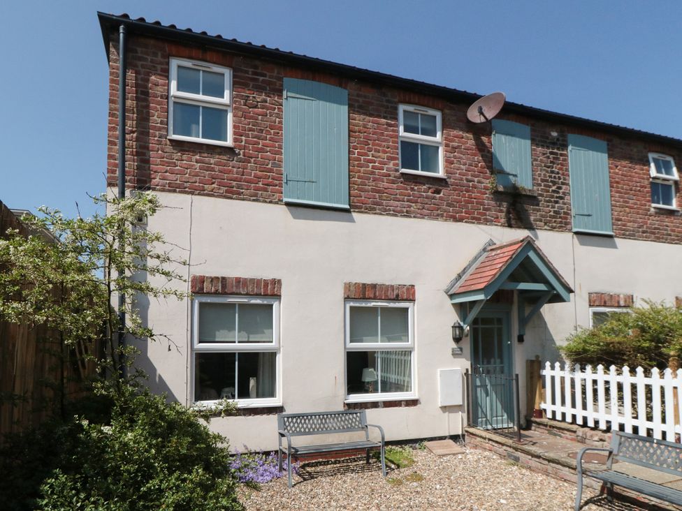A house exterior with windows, a door, and garden furniture at 4 Londesborough Mews