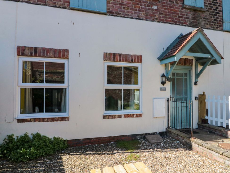 An exterior view of a house with windows and a door at Farriers Cottage in Bridlington