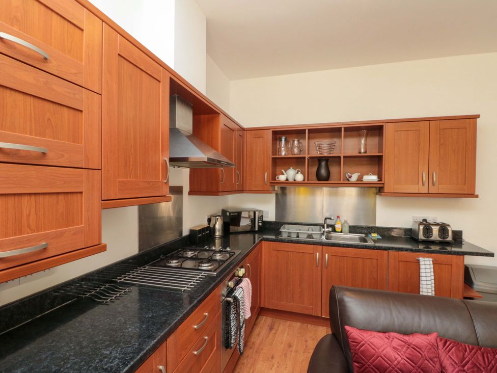 A kitchen with cabinets and appliances at Farriers Cottage in Bridlington