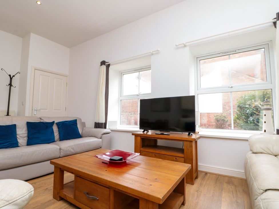 A living room with a sofa and television at Chestnut Cottage in Bridlington