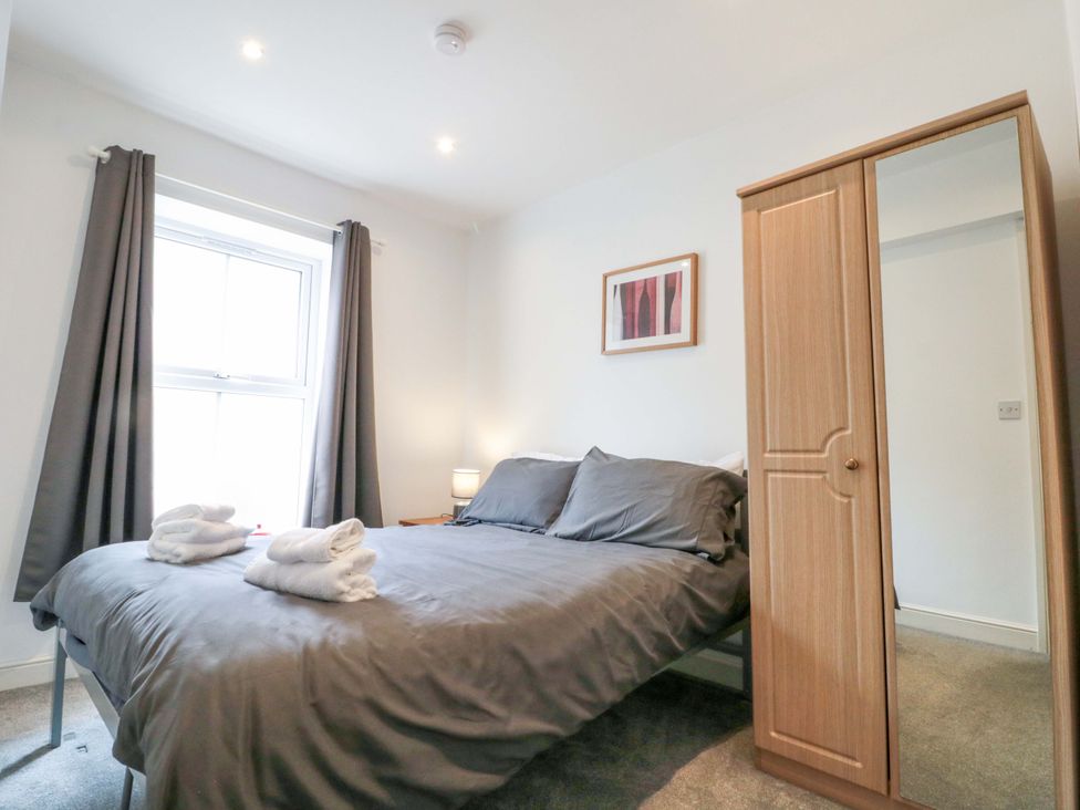 A bedroom with a bed and wardrobe at Chestnut Cottage in Bridlington