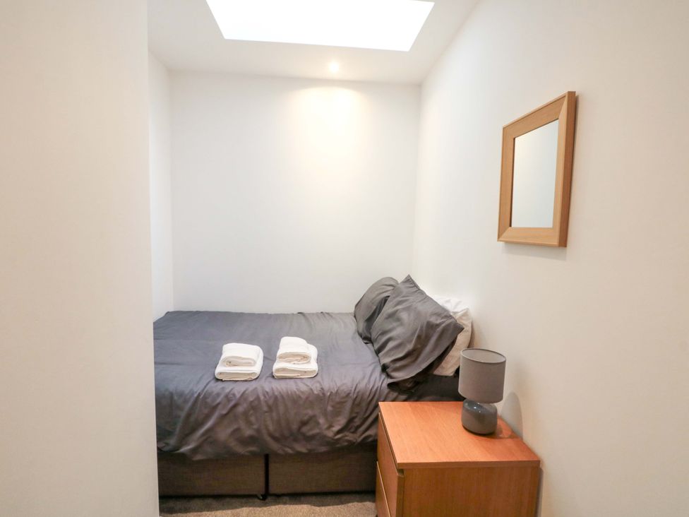 A bedroom with a bed and bedside table at Chestnut Cottage Bridlington