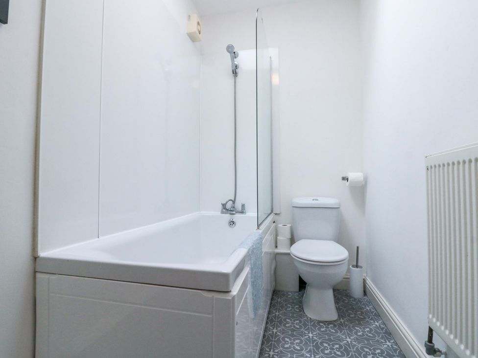 A bathroom with a bathtub and a toilet at Chestnut Cottage in Bridlington