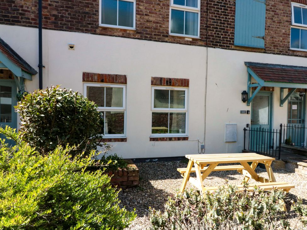An outdoor area with a bench and bushes at Chestnut Cottage in Bridlington